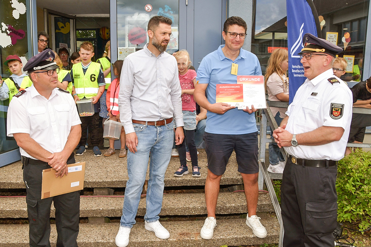 Von rechts: Heiko Bartels überreichte die Urkunde und das Ehrenschild an Schulleiter André Hollemann im Beisein von Marcel Litfin und Stefan Behme.