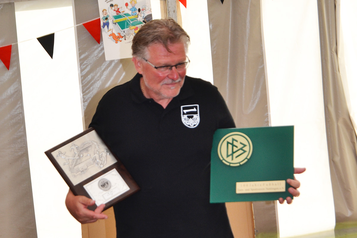 100 Jahre Fußball in Nettlingen: Der 1. Vorsitzende Andreas Bähre präsentiert die Auszeichnungen des Deutschen Fußball-Bundes und des Niedersächsischen Fußballverbandes.