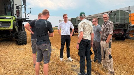 Christopher Gedeon mit den Landwirten auf dem abgeernteten Weizenfeld
