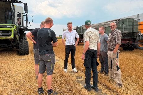 Christopher Gedeon mit den Landwirten auf dem abgeernteten Weizenfeld