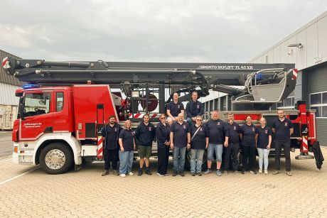 Kameradinnen und Kameraden der Freiwilligen Feuerwehr Bettrum vor der Teleskopmastbühne der  Werkfeuerwehr Volkswagen AG Wolfsburg.