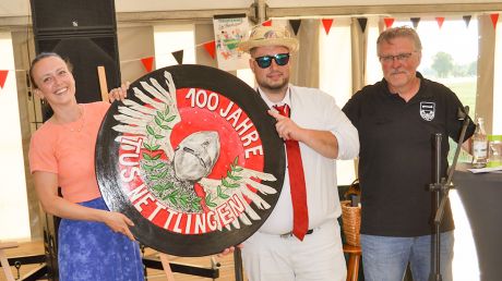 Die einmalige Ehrenscheibe zum 100-jährigen Vereinsjubiläum geht an Marcel Bodenburg (Mitte). Gestaltet wurde das Unikat von der Nettlinger Künstlerin Lisa Elias (links). Rechts gratuliert der 1. Vorsitzende Andreas Bähre.